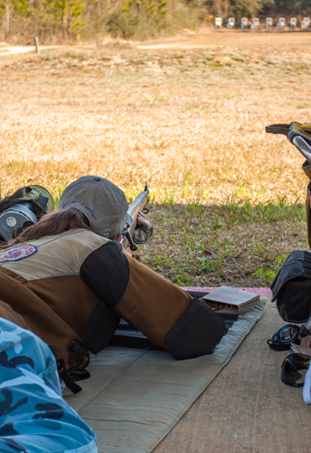 female shooting a bolt action rifle