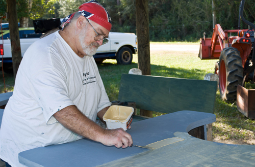 man painting table at range